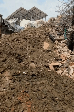 यह तस्वीर रविवार सुबह 9 की है। बिल्डिंग का निशान मिट गया है। मिट्टी का पहाड़ लगा हुआ है। यह मलबा अब हटाया जा रहा है।