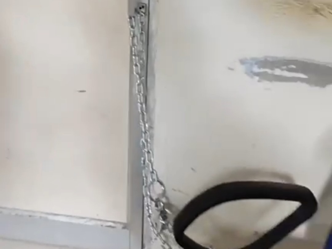 गेट पर ताला लगाकर कुर्सी से बांधी जंजीर।