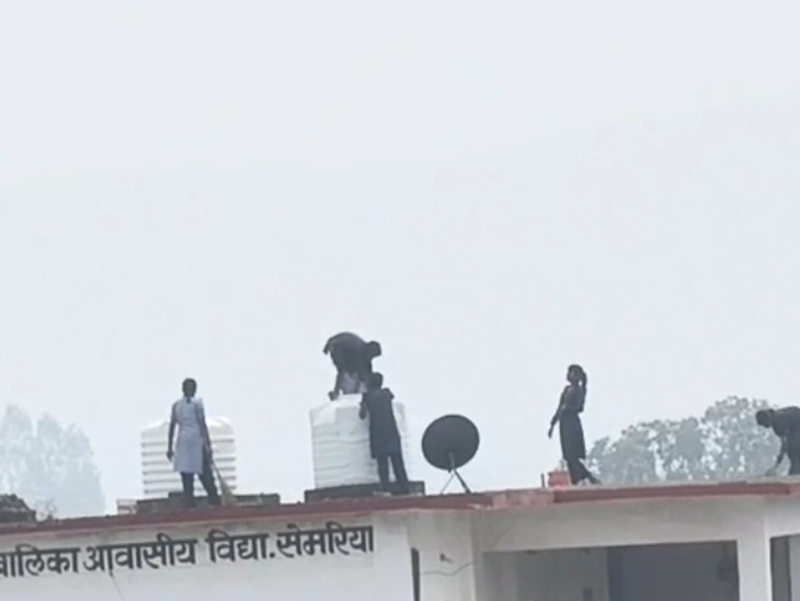 बिना मुंडेर वाली छत पर झाड़ू लगाती दिखीं छात्राएं।