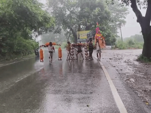 हरिद्वार में बारिश के बीच श्रद्धालु कावड़ यात्रा पर पहुंच रहे हैं।