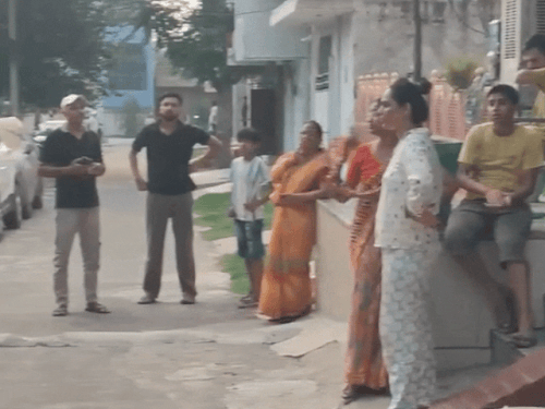 बिजली सप्लाई बाधित होने के चलते घरों के बाहर मौजूद लोग।