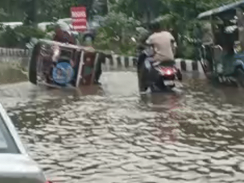 बारिश के पानी में गिरा ई-रिक्शा।