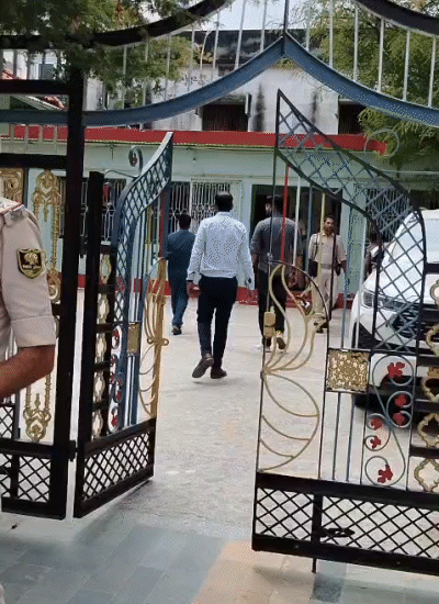रामकृपाल सिंह के आवास के अंदर जाती आयकर विभाग की टीम के सदस्य और पुलिसकर्मी।
