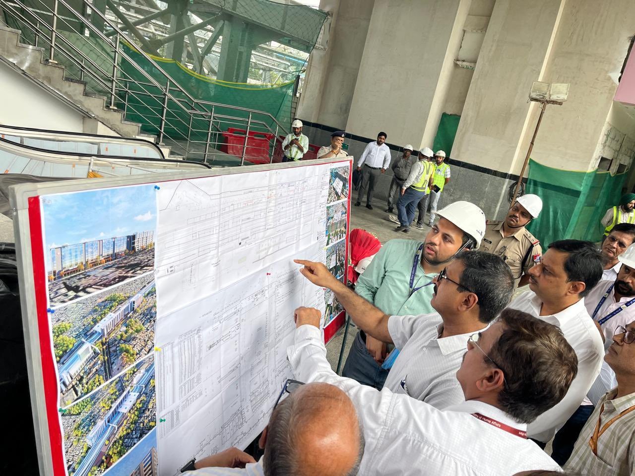 गुरुग्राम रेलवे स्टेशन पर लगे नक्शे को देखते रेलवे अधिकारी।