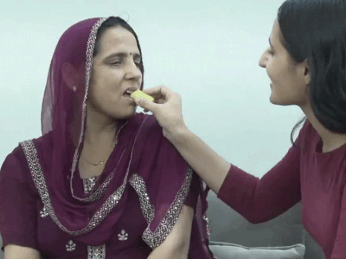 प्रीति के गोल्ड मेडल जीतने की खुशी में मां शलीन को मिठाई खिलाती बहन सोनम। वहीं, जैस्मिन के माता-पिता ने तालियां बजाकर जश्न मनाया।