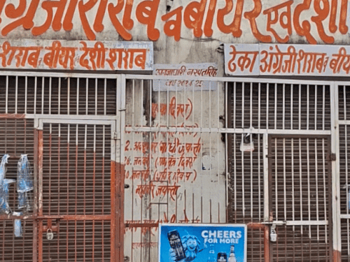 मीनाक्षी सिनेमा के सामने स्थित जगदंबा वाइन शॉप। आरोप है कि सेल्समैन युवक को सड़क पर पटककर भाग गया।