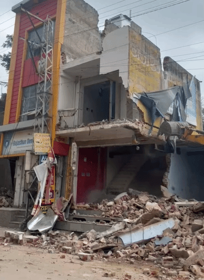 जेसीबी की मदद से सड़क पर बने निर्माण को ध्वस्त किया गया।