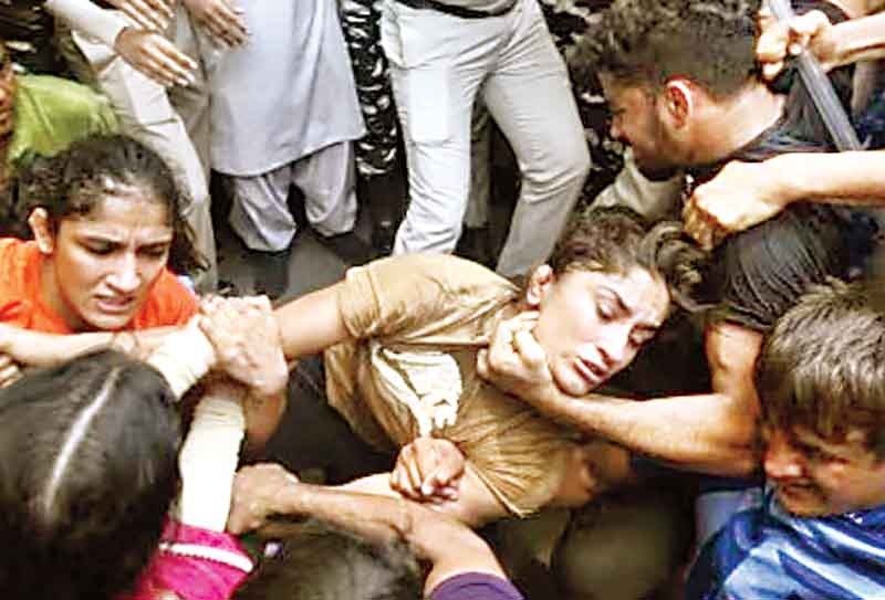विनेश फोगाट को हिरासत में लेते दिल्ली पुलिस और रैपिड एक्शन फोर्स के जवान।-फाइल