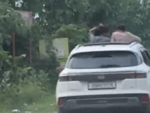 चलती कार की सनरूफ से बाहर निकलकर बाल सवांरते हुए नजर आई लड़कियां।
