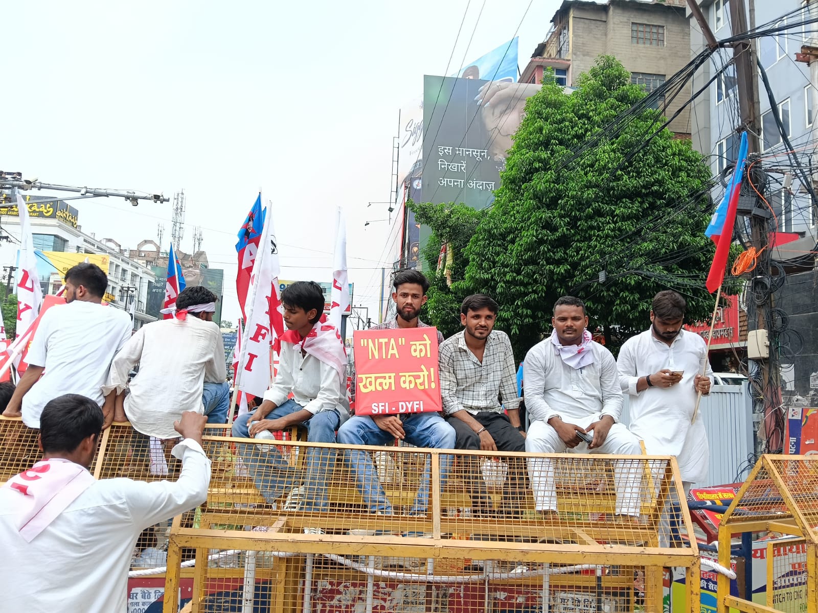 डाकबंगला चौराहे पर छात्र बैरिकेडिंग पर चढ़कर बैठे हैं। उनके हाथ में NTA को खत्म करो के पोस्टर हैं।