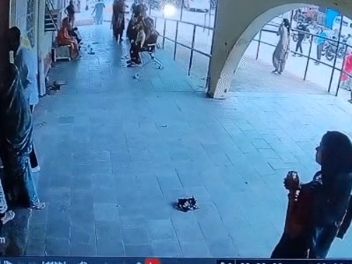 महिला अस्पताल के गेट से मोबाइल चलाते हुए बाहर निकली।