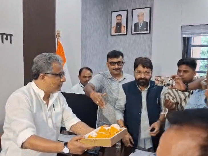 हड़ताल खत्म होने के बाद मंत्री नीतीश मिश्रा और सफाई कर्मियों ने एक दूसरे को मिठाई खिलाई।