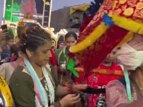 महिला कांवड़ियां के गले में फीता डालते हुए रितु इंसा।