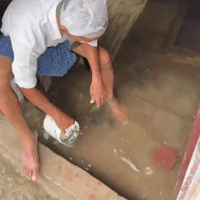 प्रयागराज ले नैनी में लोगों के घरों में घुस गया पानी, पानी निकालता बुजुर्ग।