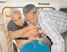 2006 में हमले के बाद प्रोफेसर सभरवाल को अस्पताल ले जाते लोग।