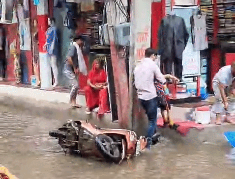 रेवाड़ी की पुरानी सब्जी मंडी में जलभराव के चलते स्कूटी गड्‌ढे में फंसने से स्कूटी चालक और बच्चा गिर गया।