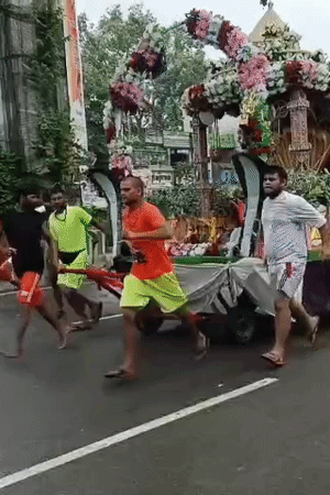 कांवड़ को रथ पर खींचते शिवभक्त।