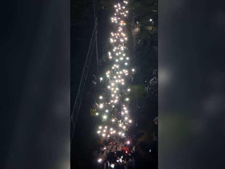 छात्र मोबाइल की फ्लैश लाइट जलाकर अपना विरोध प्रदर्शन कर रहे हैं।