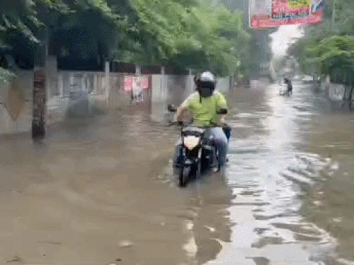 मॉडल टाउन में पानी से गुजरता बाइक सवार युवक।