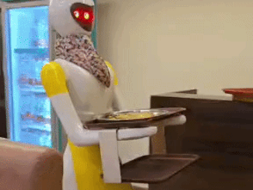 Robotic waiter delivering food to customer's table.