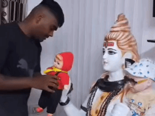हरिद्वार में भोले की प्रतिमा पर हाथ से डॉल को बांधते हुए ईशु
