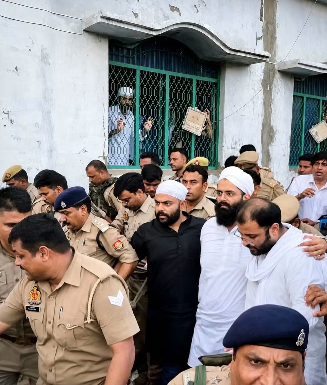पुलिस के घेरे में अतीक के तीनों बेटे उमर, अली और अहजम। सिर पर साफा पहने और आंखों पर चश्मा लगाए उमर है। वह लखनऊ जेल में बंद है।