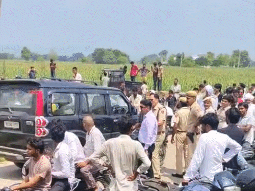 पुलिस और ग्रामीण मौके पर पहुंचकर युवक को समझाते हुए।