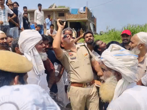 युवक से बातचीत का प्रयास करते हुए ग्रामीण व पुलिस।