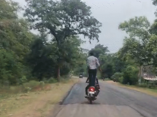 बाइक की पिछली सीट पर बैठा युवक खतरनाक करतब करता दिखाई दे रहा है।