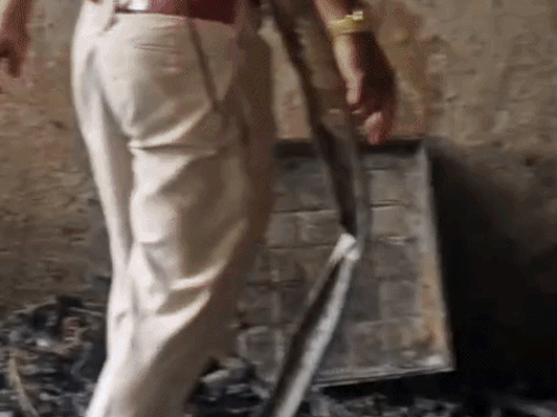 आग बुझने के बाद बचे हुए सामान को चैक करते कर्मी।