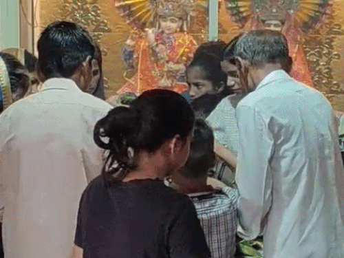 मंदिर में जलाभिषेक करत हुए लोग