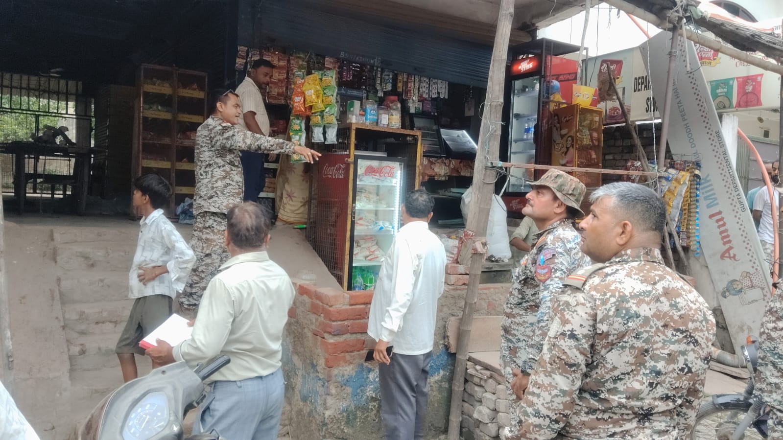 पब्लिक प्लेस पर गंदगी करने पर दुकानदार पर कार्रवाई करती नगर निगम की टीम।