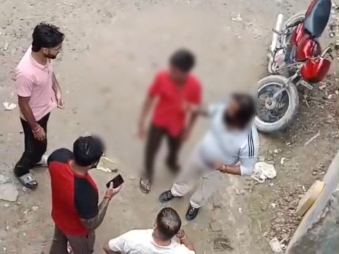 फरीदाबाद में नाबालिग लड़के को पकड़े खड़ा युवक।