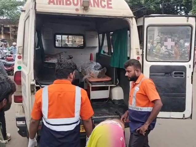 शव को सड़क से उठाते स्वास्थ्यकर्मी।