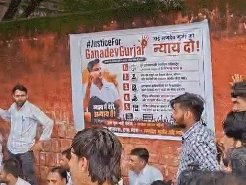 परिजन पोस्टर लगाकर प्रदर्शन कर रहे हैं।
