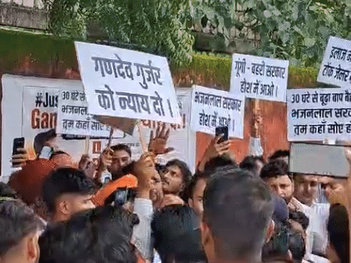 लोग हाथों में पोस्टर लेकर प्रदर्शन करते हुए।