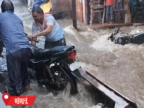 राजस्थान के झुंझुनूं में तेज बारिश के बाद रोड पर पानी नदियों के तरह बहने लगा। इसमें कई गाड़ियां रोड पर बह गईं।