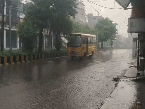 पठानकोट में बारिश के बीच जाती हुई स्कूल बस।