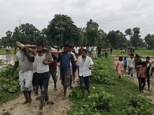 चमारी मांझी के शव को ले जाते परिजन।