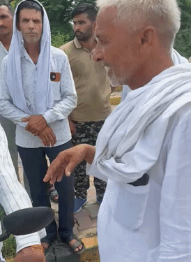 वाहन सवारों के आगे हाथ जोड़ते किसान।