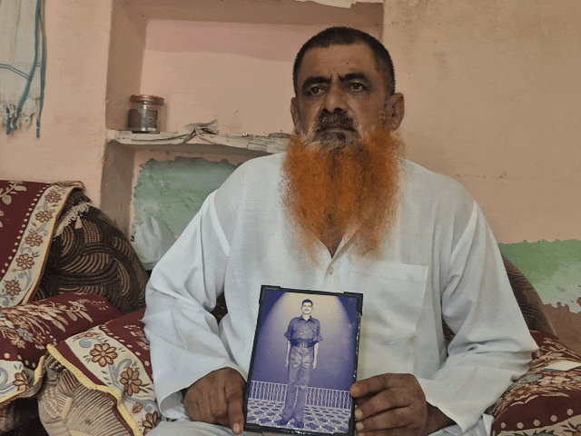 शहीद मोहम्मद इलियास खा के बेटे अब्दुल हमीद , हाथ में अपने पिता की तस्वीर लिए हुए।