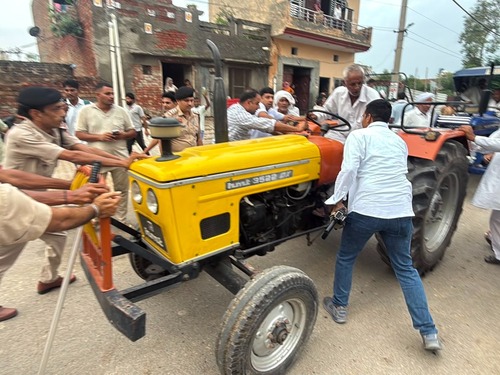 ट्रैक्टर को रोकने की कोशिश करते पुलिसकर्मी।