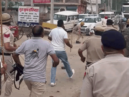 भीड़ पर पथराव करते पुलिसकर्मी।