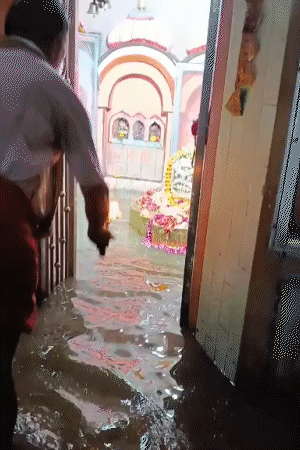 जालौन में प्राचीन भूतेश्वर महादेव मंदिर में बारिश का पानी भर गया। घुटनों तक पानी में पुजारी और श्रद्धालुओं ने भगवान शिव की आरती की।