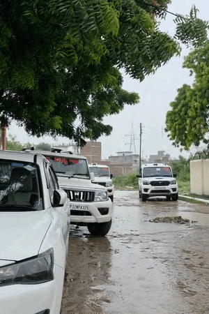 विद्यालय में सुबह 11:30 बजे समाज कल्याण विभाग के प्रमुख सचिव, सचिव, एसडीएम और स्कूल के टीचर छात्राओं से बात कर रहे हैं। जोरदार बारिश हो रही है।