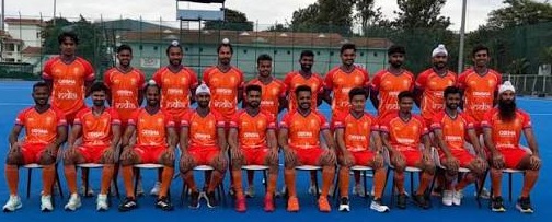 भारतीय हॉकी टीम भगवा रंग की ड्रेस में और पीछे की लाइन में राजिंद्र सिंह।
