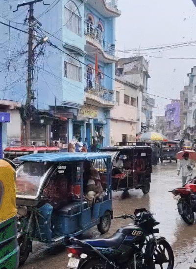 कटिहार में मूसलाधार बारिश के बीच लोग छाता लेकर जाते दिखे।