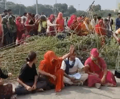 महिलाओं ने सड़क पर झाड़ियां डालकर रास्ता बंद किया और धरने पर बैठ गई