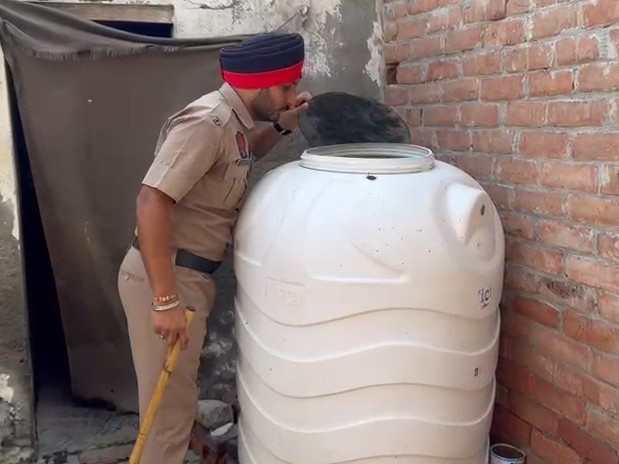 पानी की टंकी चेक करते हुए पुलिसकर्मी।