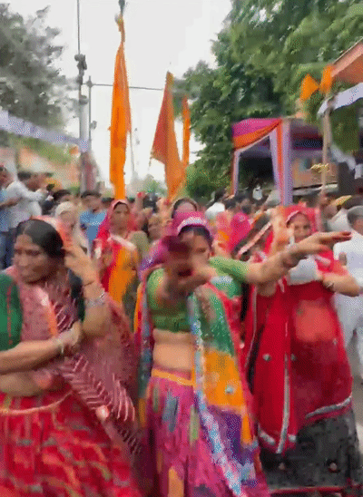 पदयात्रा में भजनों पर झूमते हुए महिला भक्त।